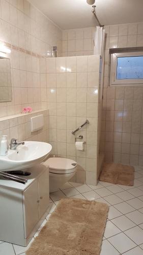 a bathroom with a sink and a toilet and a shower at Ferienwohnung Christensen in Murnau am Staffelsee
