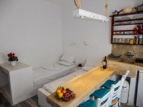 ein Zimmer mit einem Bett und einem Tisch mit Obst darauf in der Unterkunft Ioanna Rooms in Naoussa