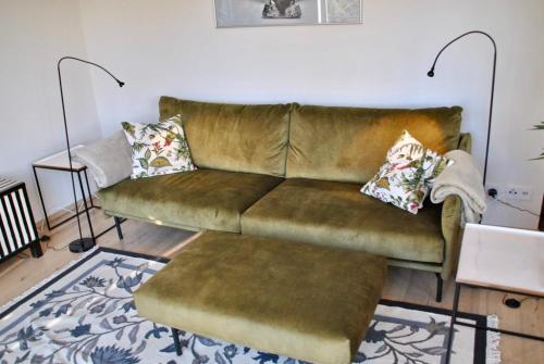 a living room with a brown couch with two pillows at Kranichhof - Studio, Loft & Atelier in Zossen