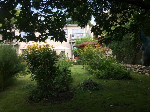 a garden with flowers and a house in the background at Kranichhof - Studio, Loft & Atelier in Zossen