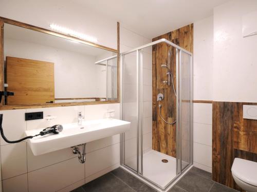 La salle de bains est pourvue d'un lavabo et d'une douche. dans l'établissement Chalet Schnee, à Mayrhofen