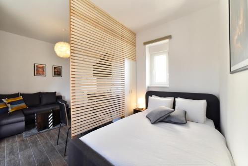 um quarto com uma cama grande e uma cadeira em Corner Apartments Savska em Zagreb