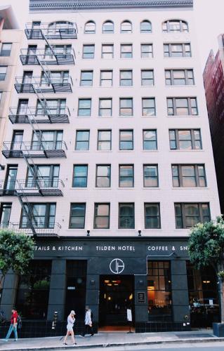a large white building with people walking in front of it at Tilden Hotel in San Francisco