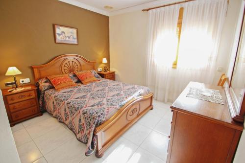 ein Schlafzimmer mit einem Bett, einer Kommode und einem Fenster in der Unterkunft El Ventorrillo - holiday home with stunning views and private pool in Benissa in Benissa