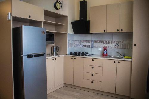 a kitchen with a refrigerator and white cabinets at Asterias Apartment in Tbilisi City