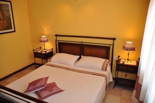 a bedroom with a large bed with two night stands at Villa Eva Luxury Villasimius in Villasimius