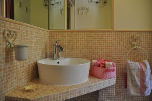 a bathroom with a white sink on a tiled wall at Villa Eva Luxury Villasimius in Villasimius