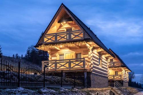 a house with lights on the front of it at DOMKI NA WIERCHU in Biały Dunajec