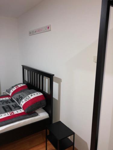 a black crib with red and white pillows in a room at Apartment 4 Rent in Bochum
