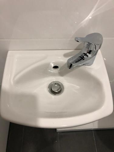 a white bathroom sink with a silver faucet at Apartment 4 Rent in Bochum