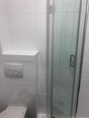 a shower with a glass door next to a toilet at Apartment 4 Rent in Bochum