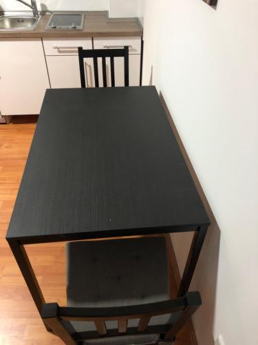 a black table with a chair in a kitchen at Apartment 4 Rent in Bochum