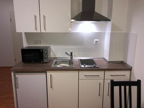 a small kitchen with a sink and a microwave at Apartment 4 Rent in Bochum