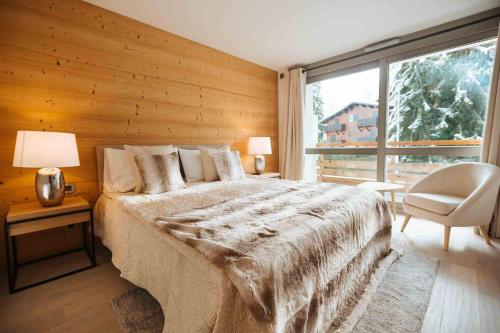 ムジェーヴにあるMegève Great apartment Lesporting Ski - AE 303のベッドルーム1室(ベッド1台、椅子、窓付)