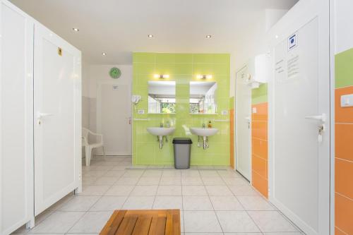 a bathroom with two sinks and a yellow wall at Kamp Romantik - glamping in Labin