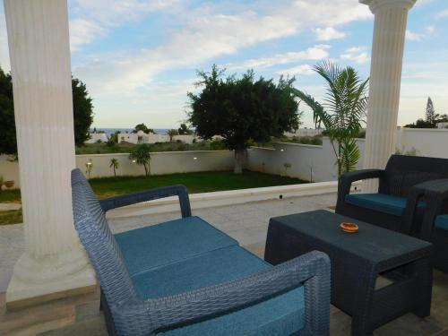 a porch with chairs and a table and a view of the ocean at Maison Alriad - Alojamiento familiar tranquilo cerca del mar con jardín, porche y parking privado en el interior de la finca no apto para fiestas in Mojácar