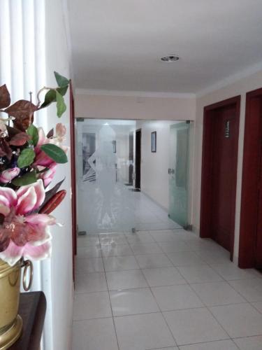 a room with a hallway with a vase of flowers at Pousada La Maison in Iguaba Grande