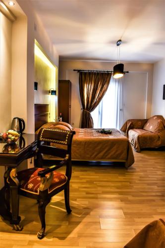 a bedroom with a bed and a chair and a couch at Tasia Mountain Hotel in Chania