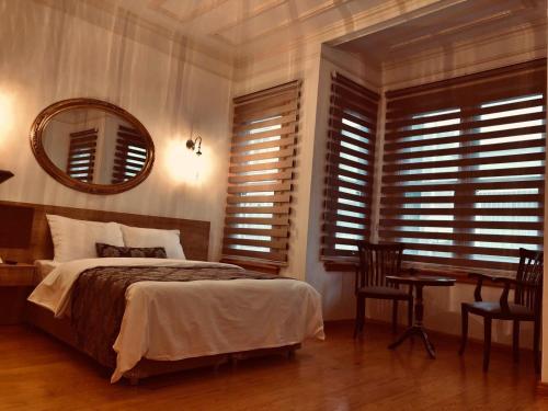 Belizia Hotel في إسطنبول: غرفة نوم بسرير ومكتب ومرآة