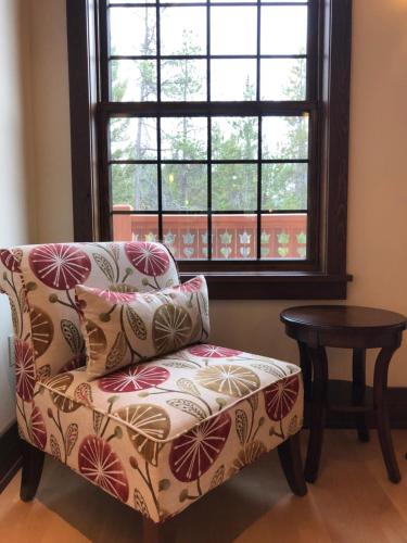 Great Northern Resort (Lodge) في ويست غلاسير: كرسي وطاولة في غرفة مع نافذة