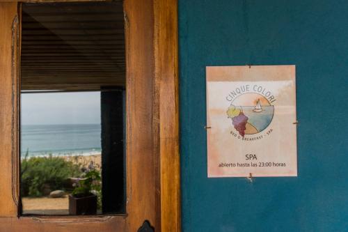 a sign on a wall next to a beach at Cinque Colori Bed & Breakfast- Spa in Algarrobo
