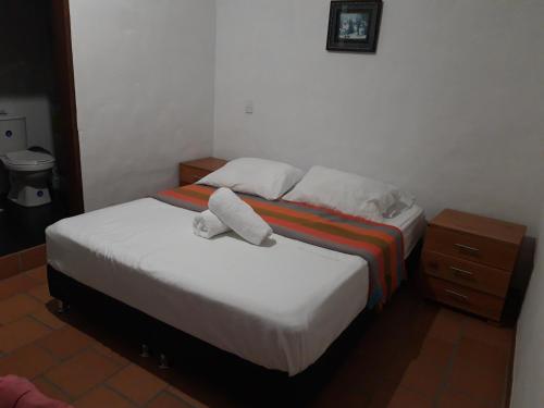 a bedroom with a bed with two towels on it at Casa Doña Rosaura Barichara ALQUILER Entero in Barichara