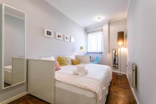 1 dormitorio con 1 cama blanca grande y espejo en Hipster`s Dream by the River, en Oporto