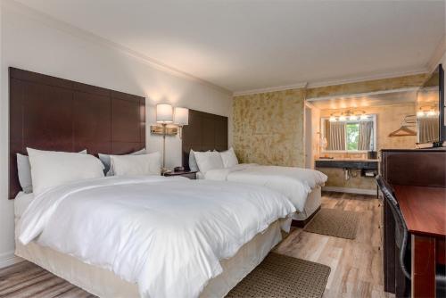 Una habitación de hotel con dos camas grandes y un escritorio. en Fairway Inn, en Berryville