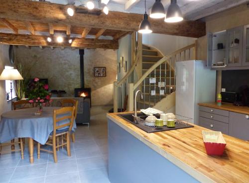 Siguerにあるla grange de clotildeのカウンターとテーブル付きのキッチンが備わります。