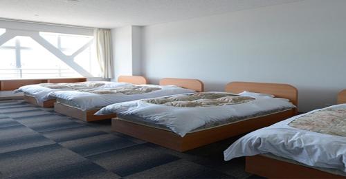 a row of beds in a room with a window at KIBOTCHA / Vacation STAY 8354 in Higashimatsushima