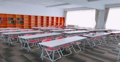 uma sala de aula com secretárias e cadeiras vermelhas num quarto em KIBOTCHA / Vacation STAY 8351 em Higashimatsushima