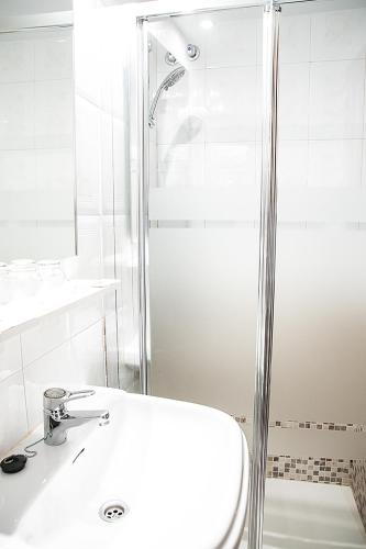 a white bathroom with a sink and a shower at Hotel La Rambla in Biescas