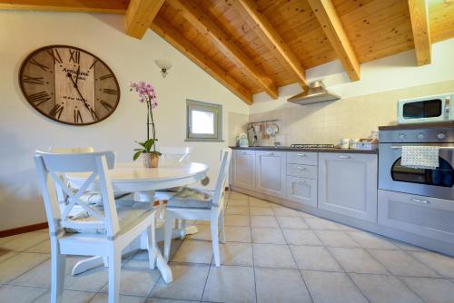 a kitchen with a table and a clock on the wall at Villa dei Venti - Comfort Holiday in Bergamo