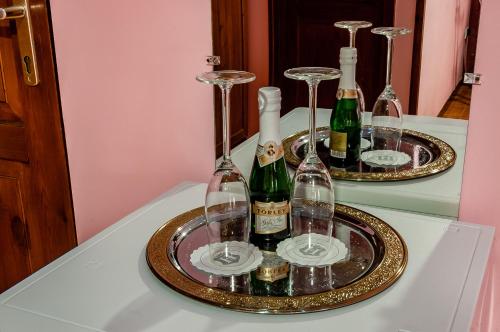 a tray with wine bottles and glasses on a table at Bástya Hotel in Makó