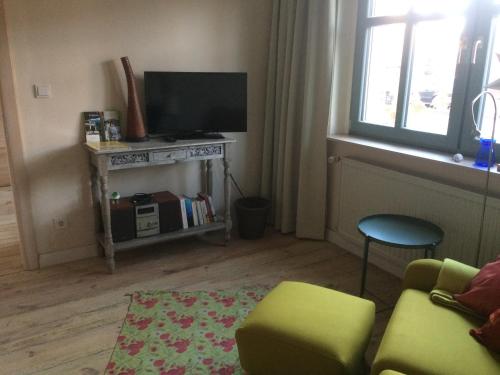a living room with a couch and a television at Kranichhof - Studio, Loft & Atelier in Zossen