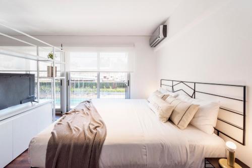 1 dormitorio blanco con 1 cama grande y TV de pantalla plana en Top Rentals Dorrego en Buenos Aires
