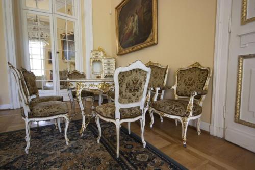 a dining room with chairs and a table and a table and a painting at Hotel butikowy Pałac Jabłonna in Jabłonna