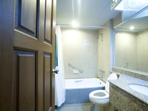 y baño con aseo, bañera y lavamanos. en Fortuna Hotel, en Bangkok