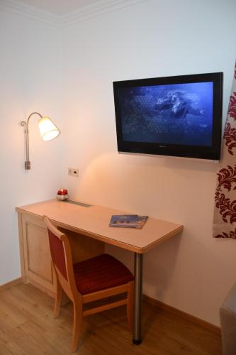 a desk in a room with a tv on the wall at Gästehaus Elisabeth in Radstadt