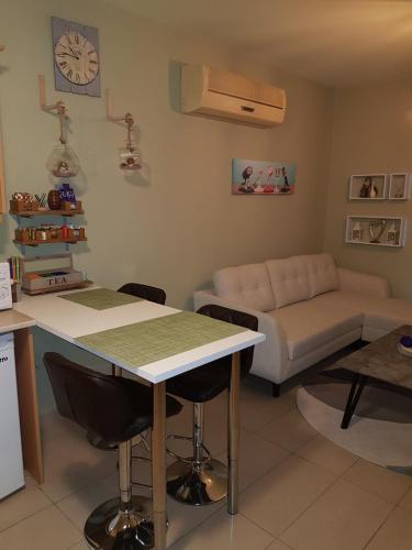 a kitchen and living room with a table and a couch at Ria Court 33 in Larnaka