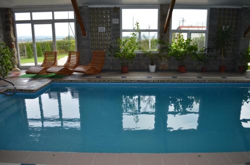 a large swimming pool with chairs and windows at Famozclub in Bakov nad Jizerou