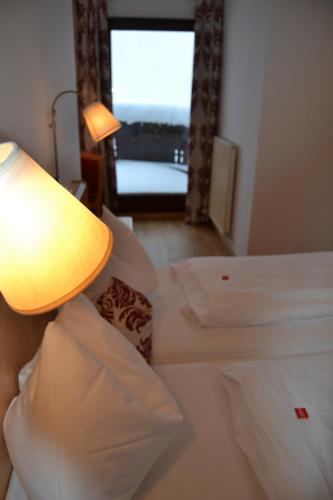 a room with two beds and a lamp and a window at Gästehaus Elisabeth in Radstadt