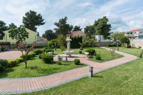 een park met een bank en een fontein bij Hotel Miramare in Vodice