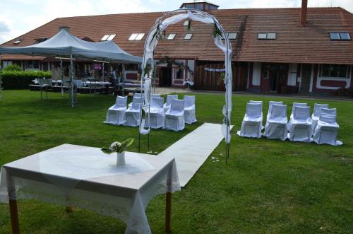 a group of white chairs and a table and a tent at Famozclub in Bakov nad Jizerou