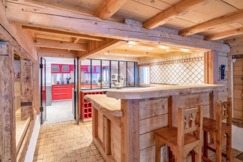 Il comprend une grande cuisine avec un comptoir et des plafonds en bois. dans l'établissement Le Charmélie 1600, à Flaine