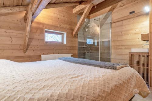 a bedroom with a bed in a wooden cabin at Le Charmélie 1600 in Flaine