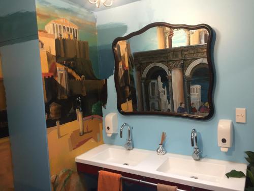 a bathroom with two sinks and a large mirror at Atlantis Backpackers in Picton