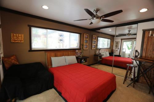Schlafzimmer mit einem roten Bett und einem Ventilator in der Unterkunft Kaza Kokos in Oceanside