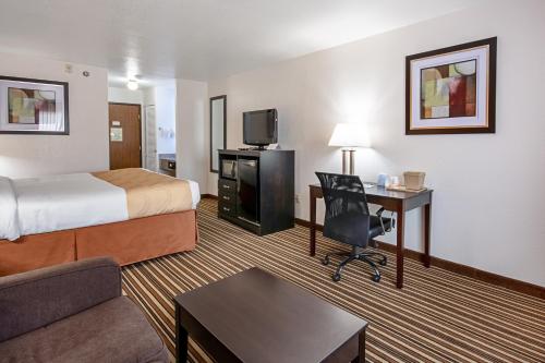 a hotel room with a bed and a desk at Quality Inn in Dodge City