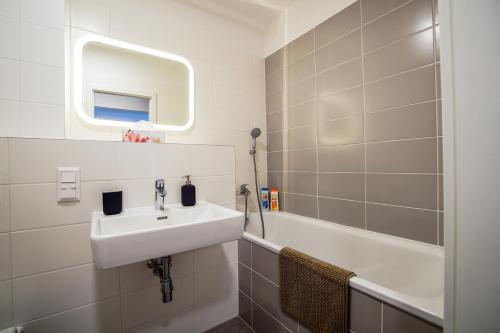 a bathroom with a sink and a bath tub at Cvernovka Business&Leisure apartment by Kovee in Bratislava